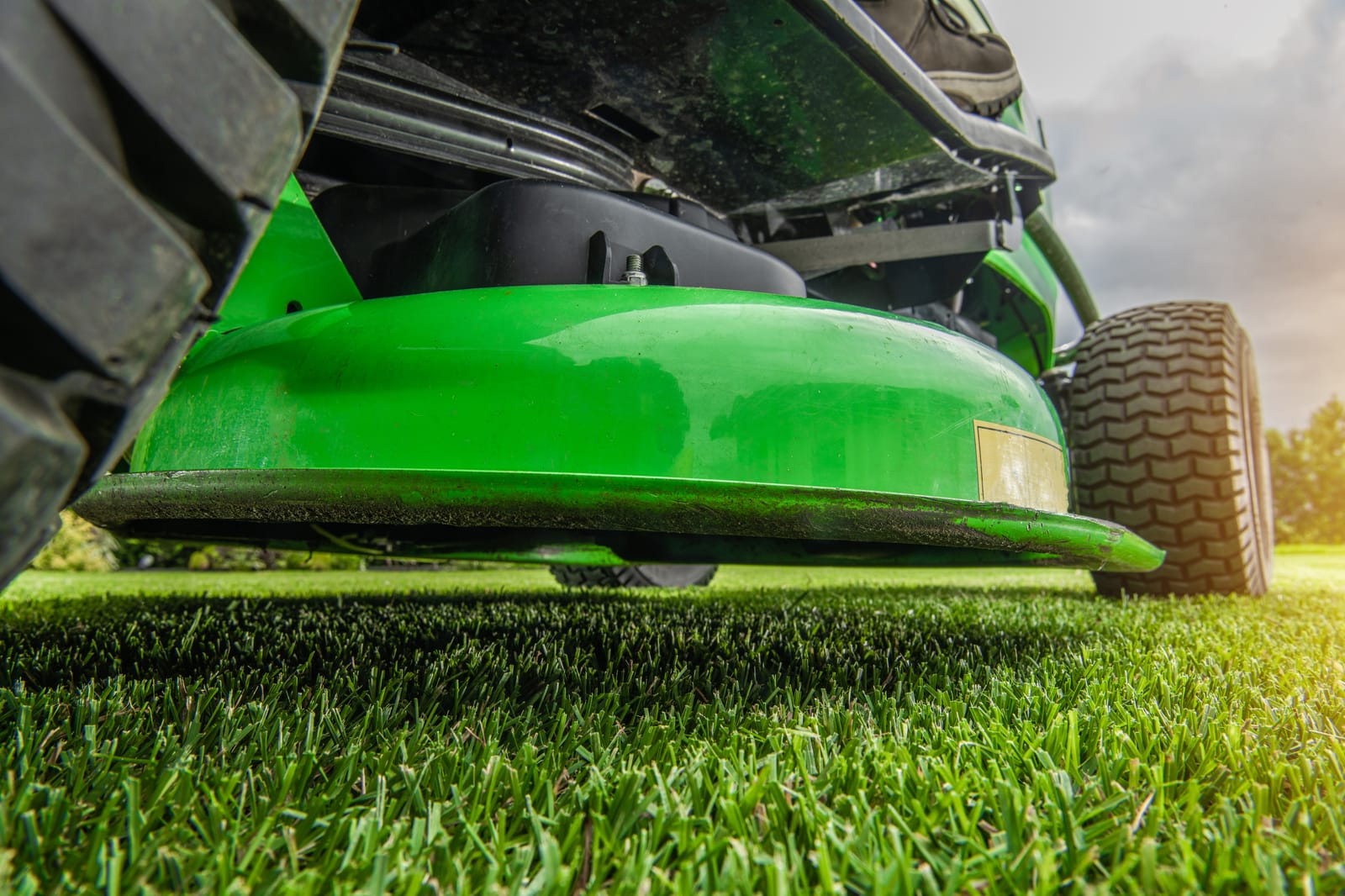 A walk-behind mower being serviced on the grass at the end of the season